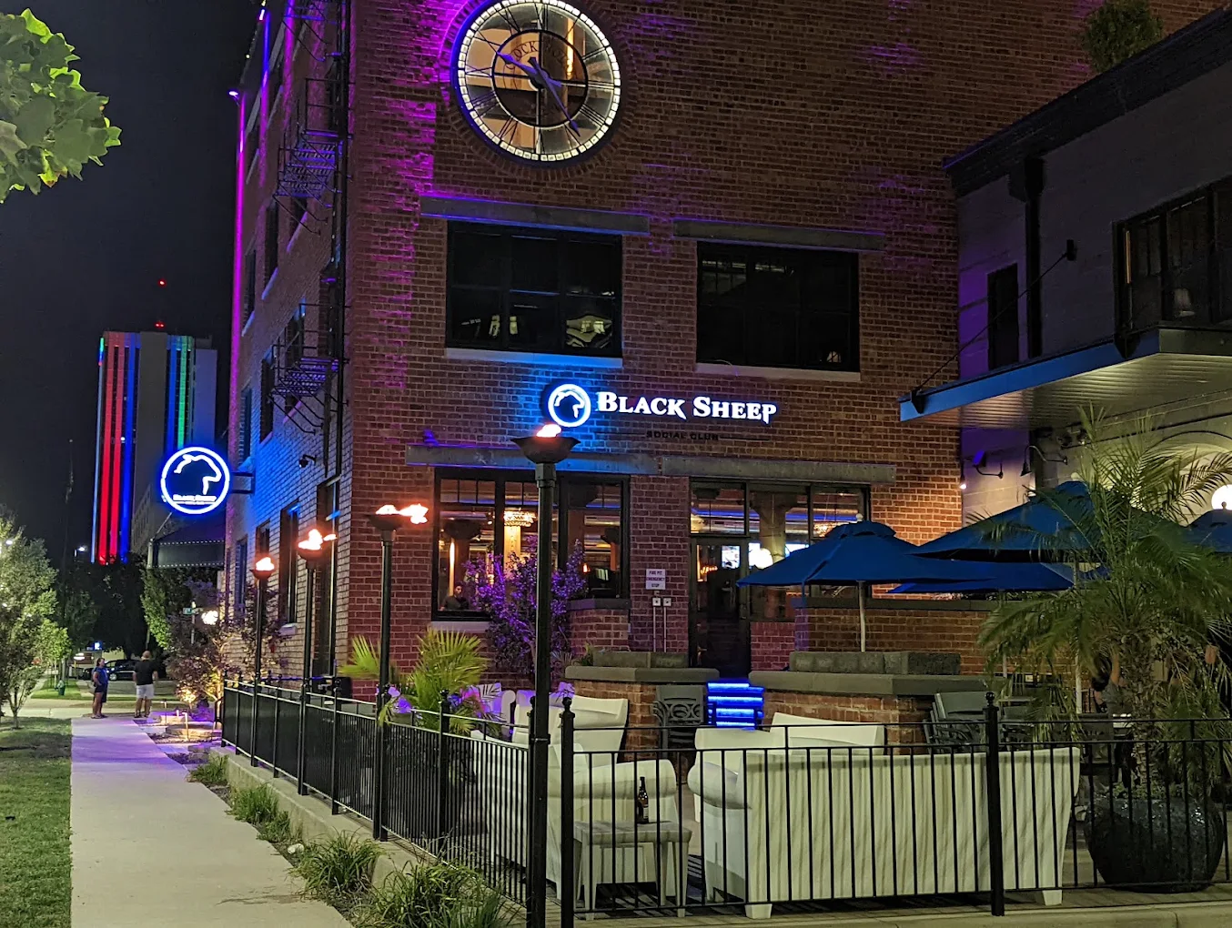 Black Sheep Social Club patio with multiple natural gas torches and linear fire features illuminated at night